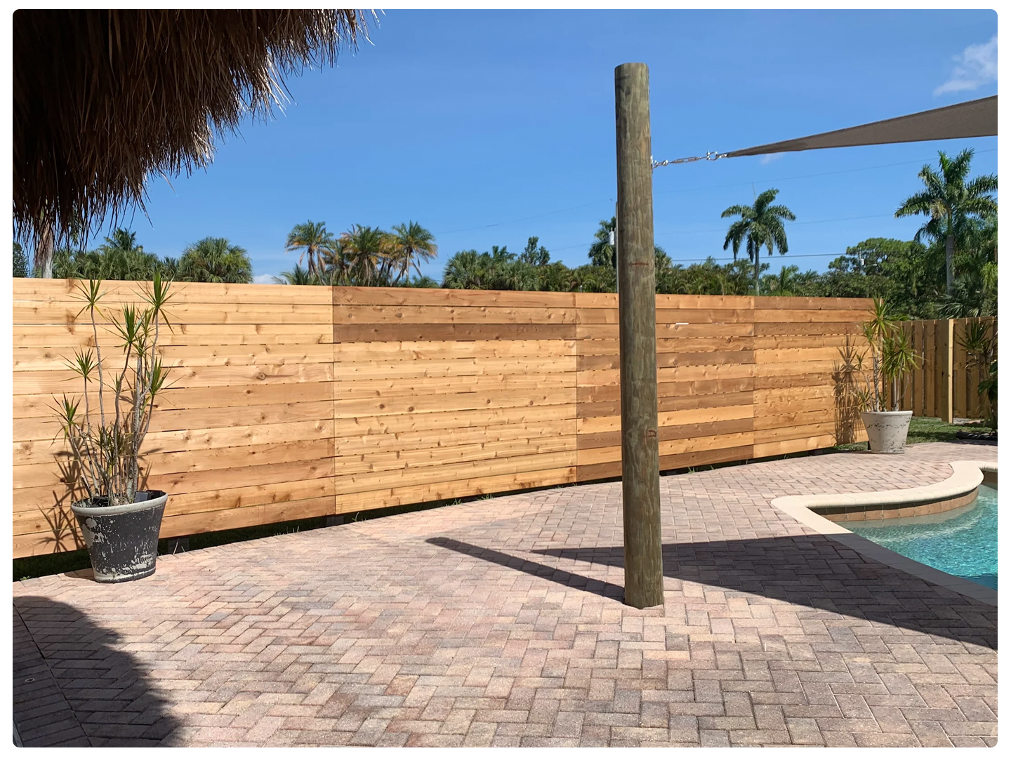 Outdoor pool area with a wooden fence of Rosewood Fencing,